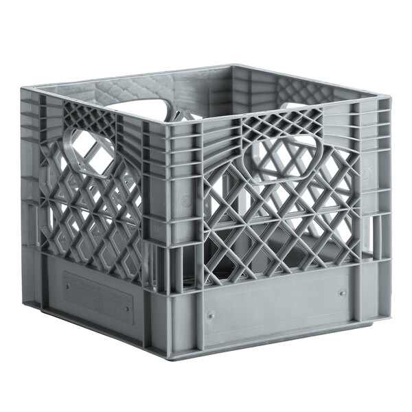 A grey plastic milk crate with handles and holes.