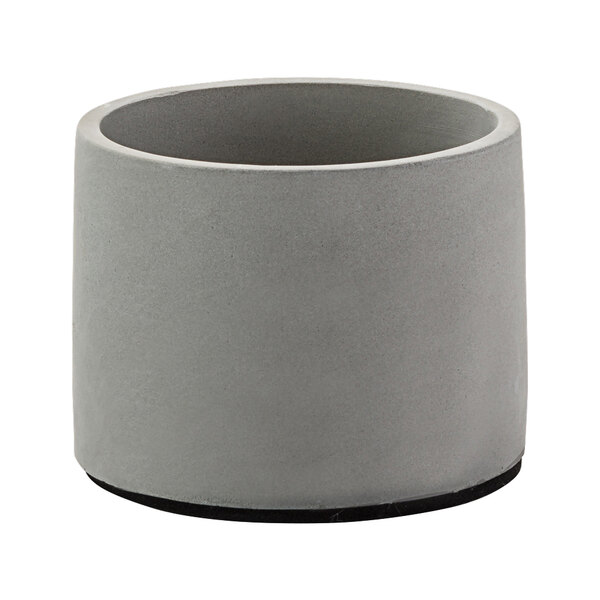 A grey concrete cylinder planter with black rubber feet.