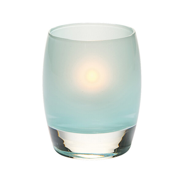 A Hollowick Contour satin seafoam glass votive with a lit candle inside.