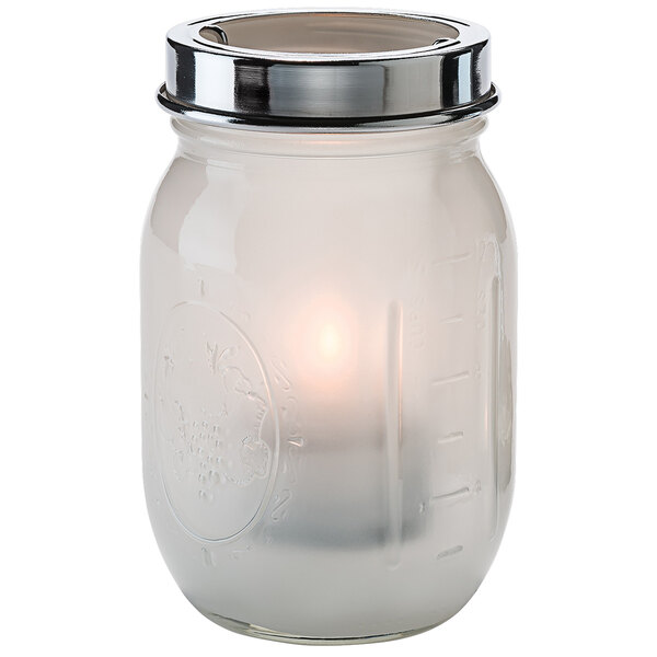 A satin linen glass jar with a lit candle inside.
