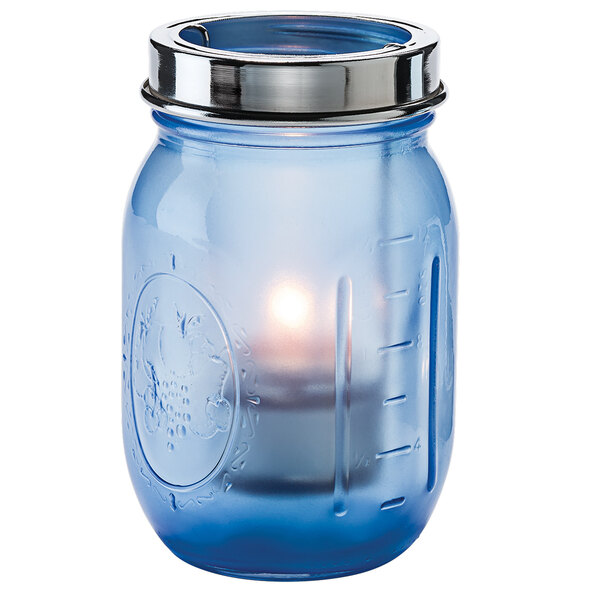 A Dark Blue Satin glass jar with a lit candle inside and a tealight cradle.