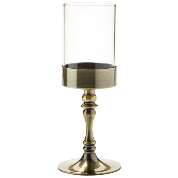 A Hollowick glass cylinder candle holder with an antique brass base.