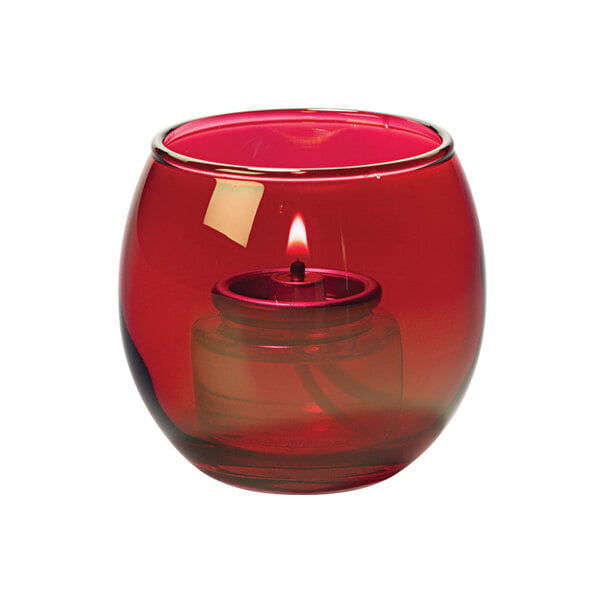 A Hollowick ruby glass tealight lamp with a lit candle inside.