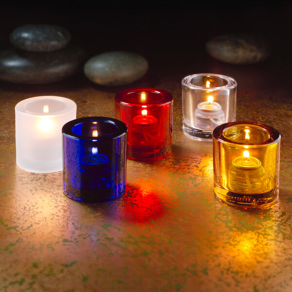 A group of Hollowick round ruby jewel glass tealight candles on a table.