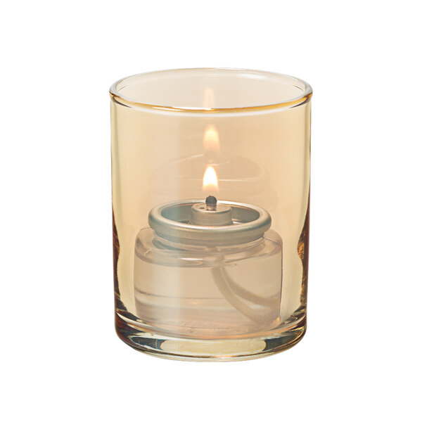 A gold glass cylinder tealight holder with a lit candle inside.