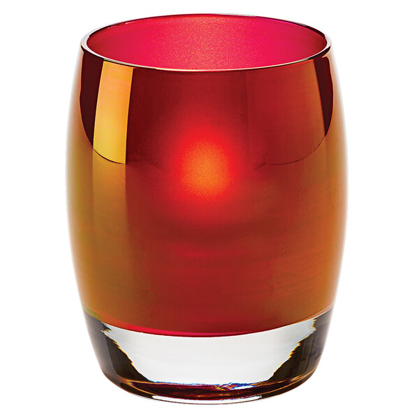 A Hollowick ruby gold glass votive with a red candle inside.