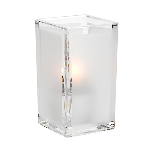 A clear glass Hollowick Quad Panel Votive with a lit candle inside.