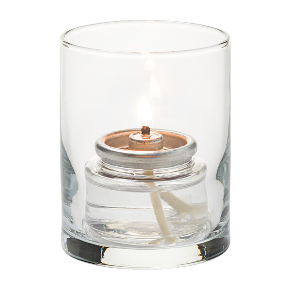 A Hollowick clear glass cylinder tealight holder with a lit candle inside.
