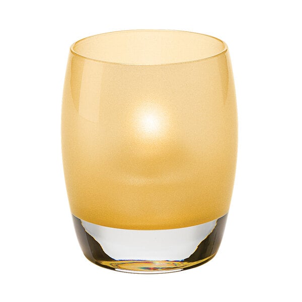 A Hollowick satin gold glass votive with a lit candle inside.