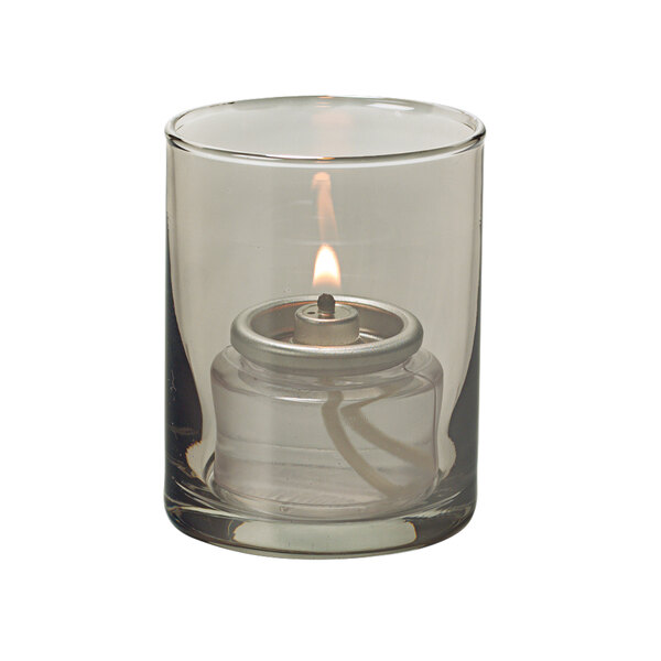 A Hollowick Smoke Lustre glass cylinder with a lit tealight inside.