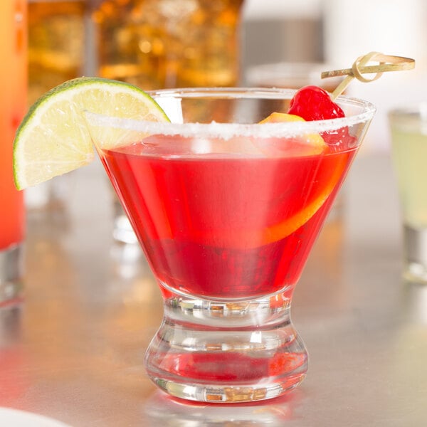 A Libbey Cosmopolitan cocktail glass with a red drink and lime and cherry garnish.