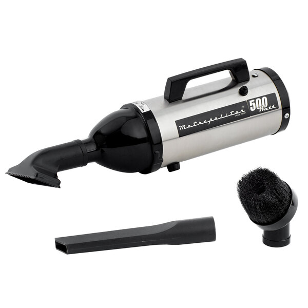 A white MetroVac Metropolitan Evolution handheld canister vacuum with a brush.