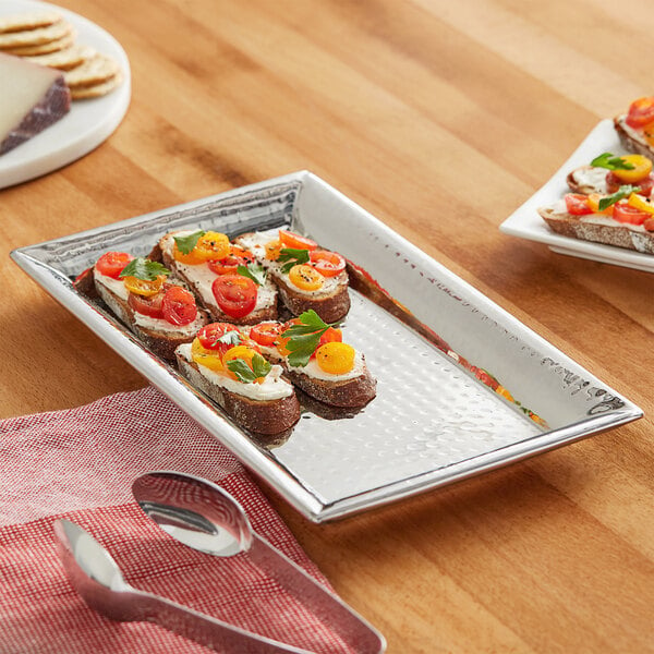 A rectangle stainless steel tray with food on it on a table.