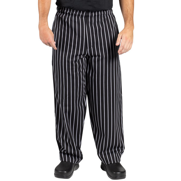 A person wearing Uncommon Chef black and white chalk stripe chef pants.