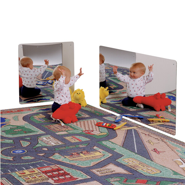 A baby sitting on a rug with a Jonti-Craft children's wall mirror and toys.