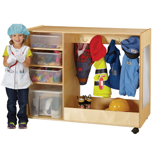 A child standing next to a Jonti-Craft wooden dress up storage unit.
