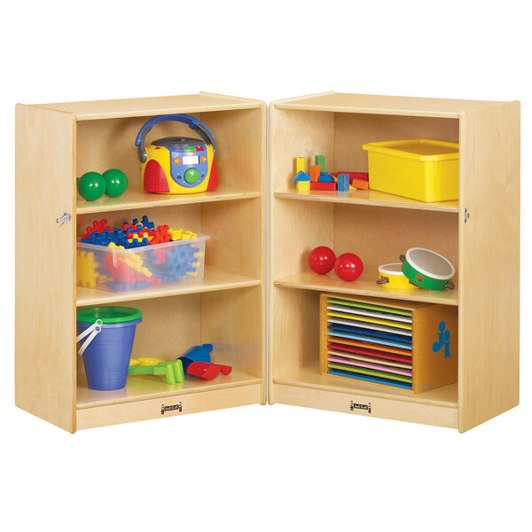 A Jonti-Craft wooden storage cabinet with toys on it.