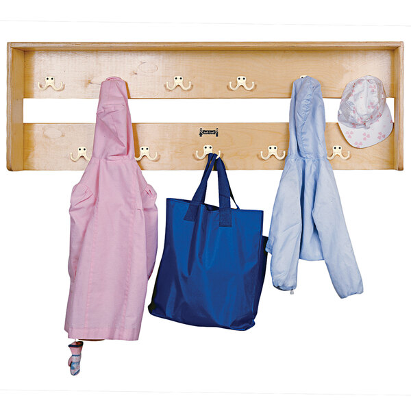 A Jonti-Craft wooden coat rack with clothes and a hat on it.