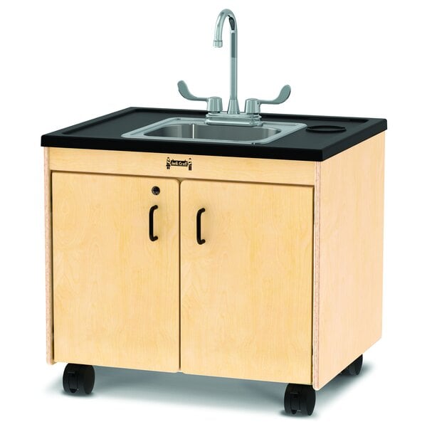 A Jonti-Craft mobile clean hands helper with a stainless steel sink on a wooden cabinet with wheels.