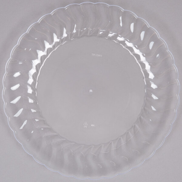 A Fineline Flairware clear plastic plate with a scalloped edge.