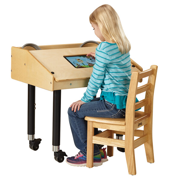 A girl sitting at a wooden table using a Jonti-Craft wood tablet table.