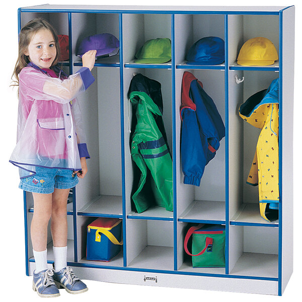 A young girl wearing a yellow shirt standing next to a Rainbow Accents blue and gray coat locker.