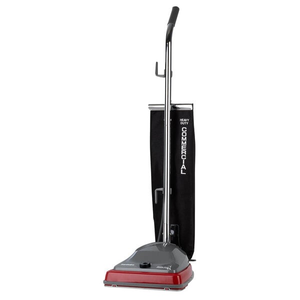 A Sanitaire TRADITION vacuum cleaner with a red handle.