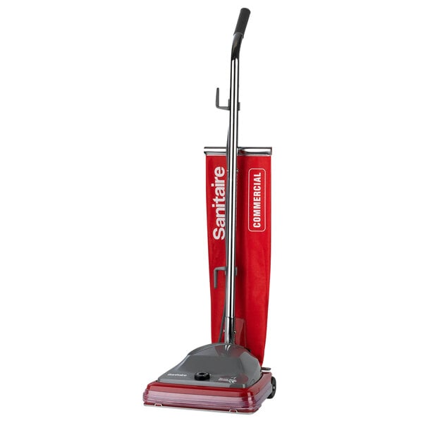 A red Sanitaire TRADITION upright vacuum cleaner with a handle.