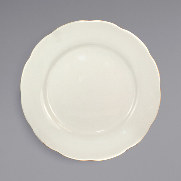 An ivory stoneware plate with a scalloped edge.