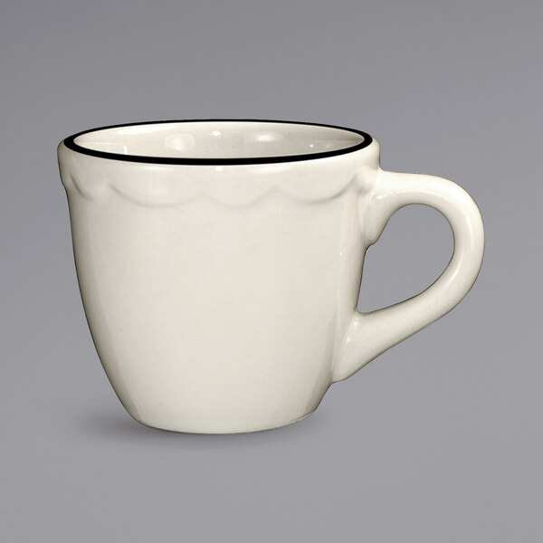 An ivory stoneware espresso cup with a black rim.