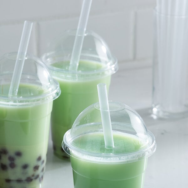 Three green drinks with Choice translucent pointed unwrapped straws in white plastic cups.