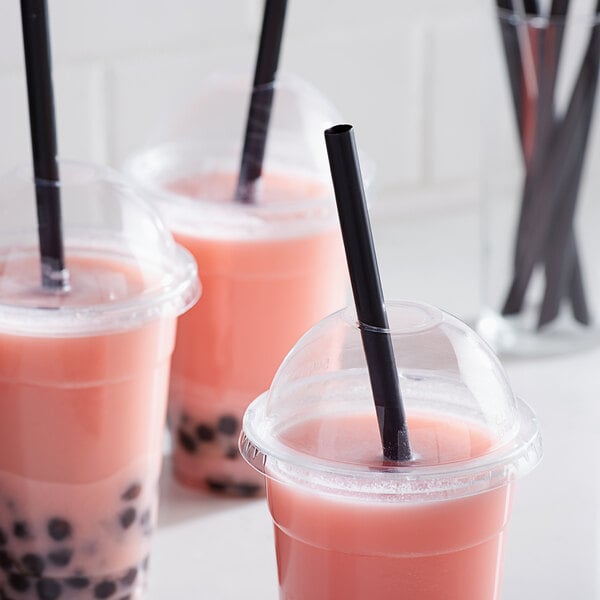 A pink plastic cup with a black straw in it.