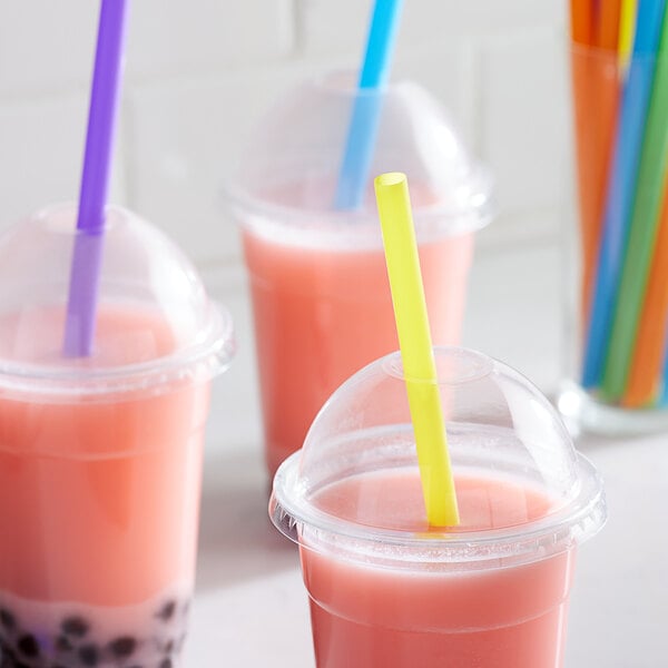 A close-up of a neon straw in a pink drink.