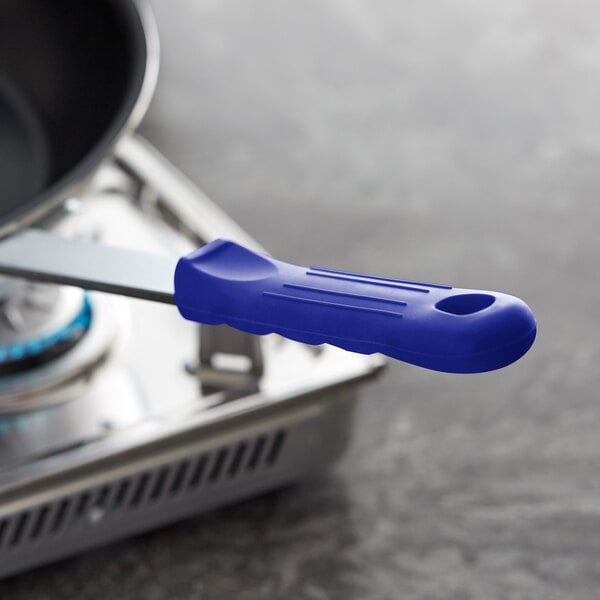 A blue Choice removable silicone handle sleeve on a frying pan.