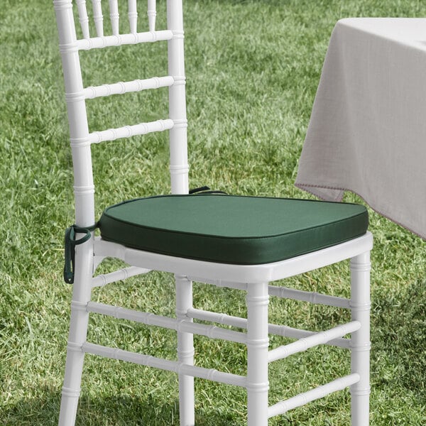 A white chair with a Lancaster Table & Seating hunter green cushion on it.