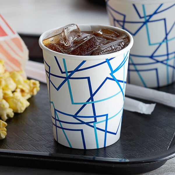 A tray with a Choice paper cold cup filled with soda and ice and a tray with popcorn and a drink in a Choice paper cold cup.