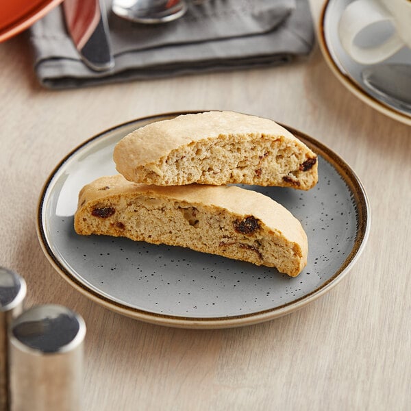 A piece of biscotti on an Acopa Keystone granite gray stoneware plate on a table in a bakery display.