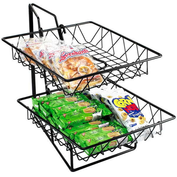 A black wire rack with two square baskets of snacks on a counter.