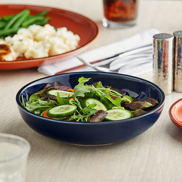 An Acopa Keystone Azora Blue stoneware bowl filled with salad on a table.