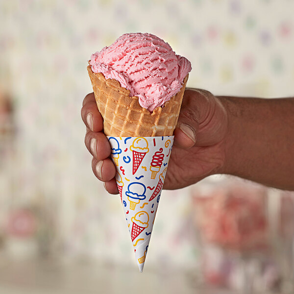 A hand holding a Keebler Colosso Waffle Cone with pink ice cream.