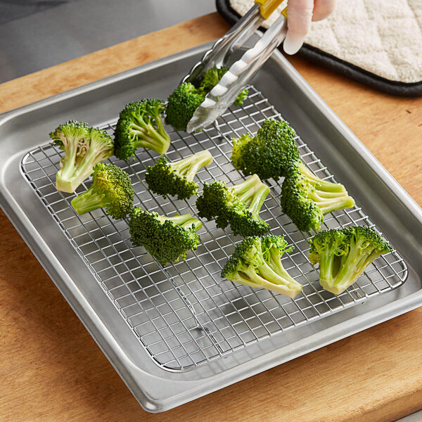 Broccoli on a footed metal rack.