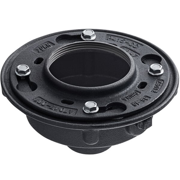 A black metal Zurn floor drain with a hole for a black plastic pipe fitting.