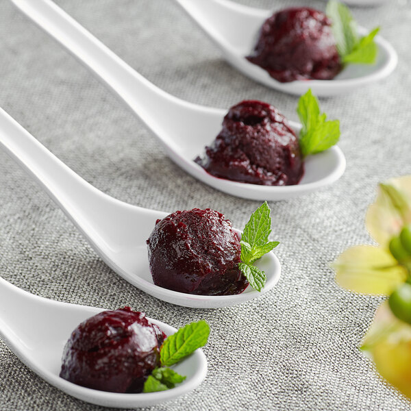 A spoonful of Les Vergers Boiron blackcurrant puree on a spoon.