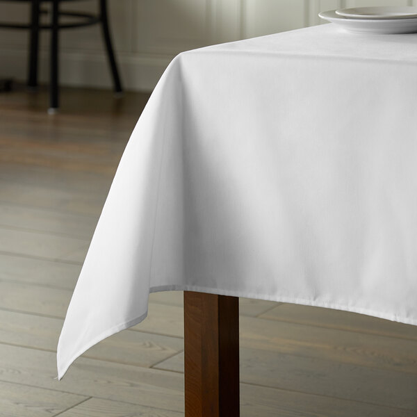 A table with a white Intedge poly cotton blend tablecloth.