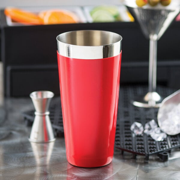 A red stainless steel Tablecraft cocktail shaker on a counter.