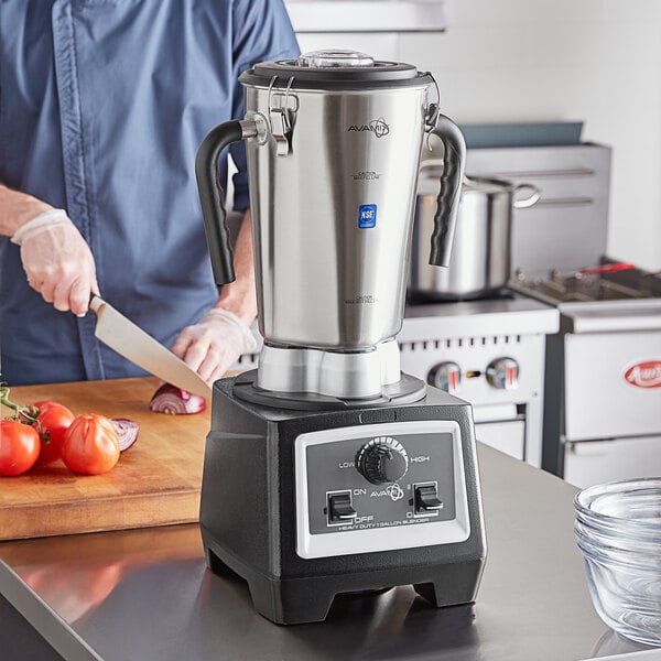A man using an AvaMix stainless steel commercial food blender on a kitchen counter.
