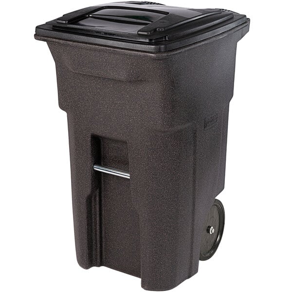 A black Toter rectangular trash can with wheels and a lid.