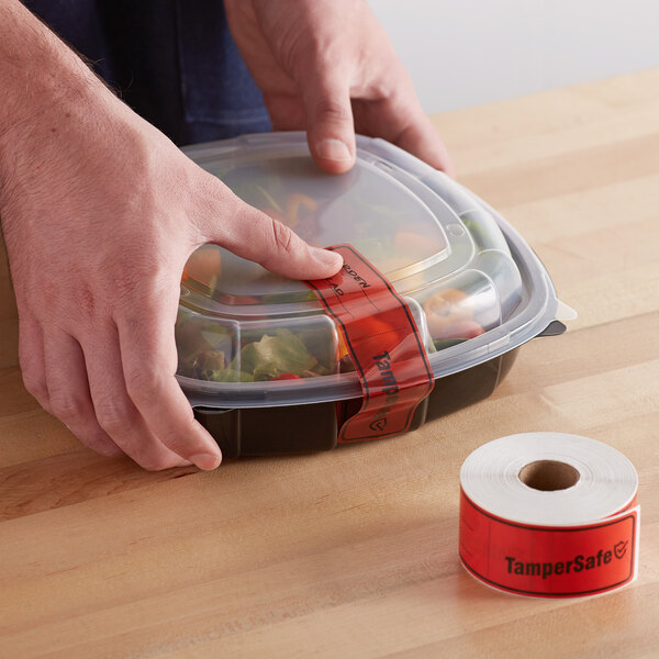 A person using a TamperSafe red plastic label on a plastic container of food.