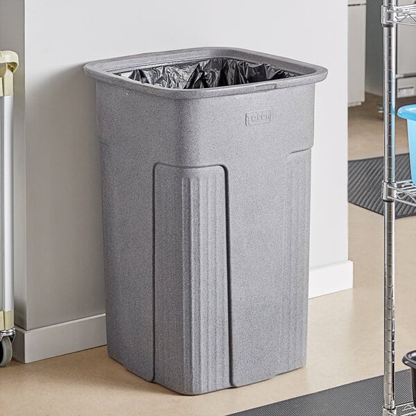 A Toter grey plastic trash can in a corporate cafeteria.