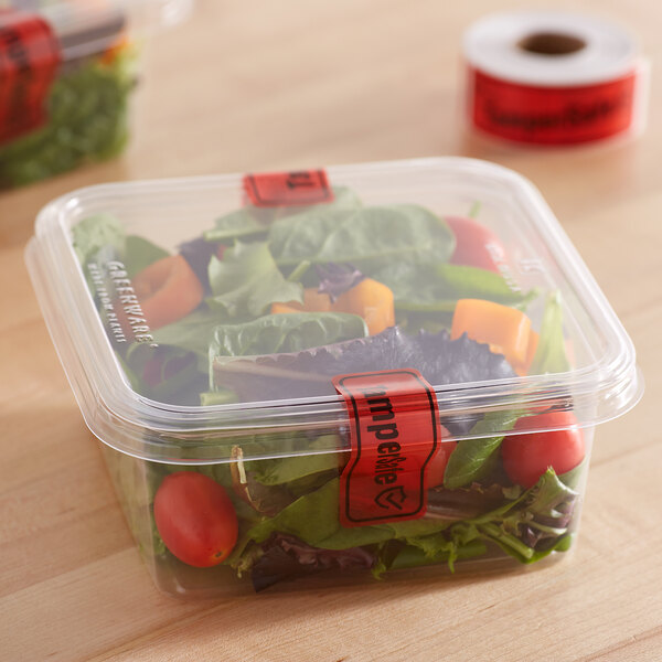 A plastic container of salad with a red TamperSafe label.